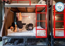 Кровать в общем номере с балконом и с красивым видом из окна в Sleeper Hostel