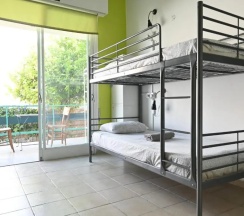 Кровать в общем номере с балконом и с красивым видом из окна в Lemongrass Hostel
