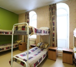 Кровать в общем номере с красивым видом из окна в Пётр первый